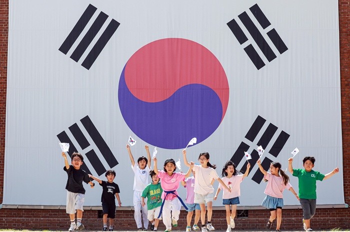제81주년 광복절을 하루 앞둔 14일 서울 서대문구 서대문형무소역사관 대형 태극기 앞에서 어린이들이 직접 만든 태극기를 흔들며 힘차게 뛰고 있다. 2026.8.14/뉴스1