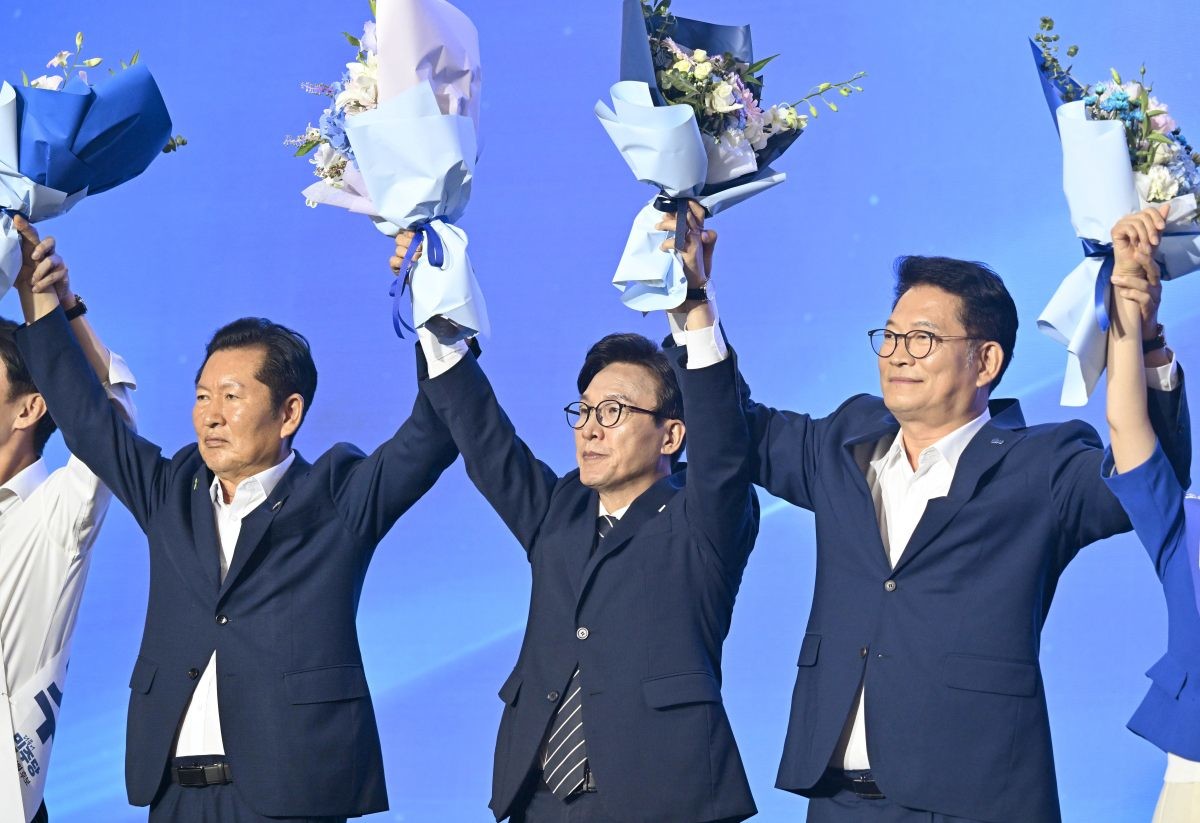 김민석 더불어민주당 신임 당대표가 당대표 당선이 확정되자 정청래, 송영길 후보와 꽃다발을 들고 인사를 하는 모습. / 뉴스1