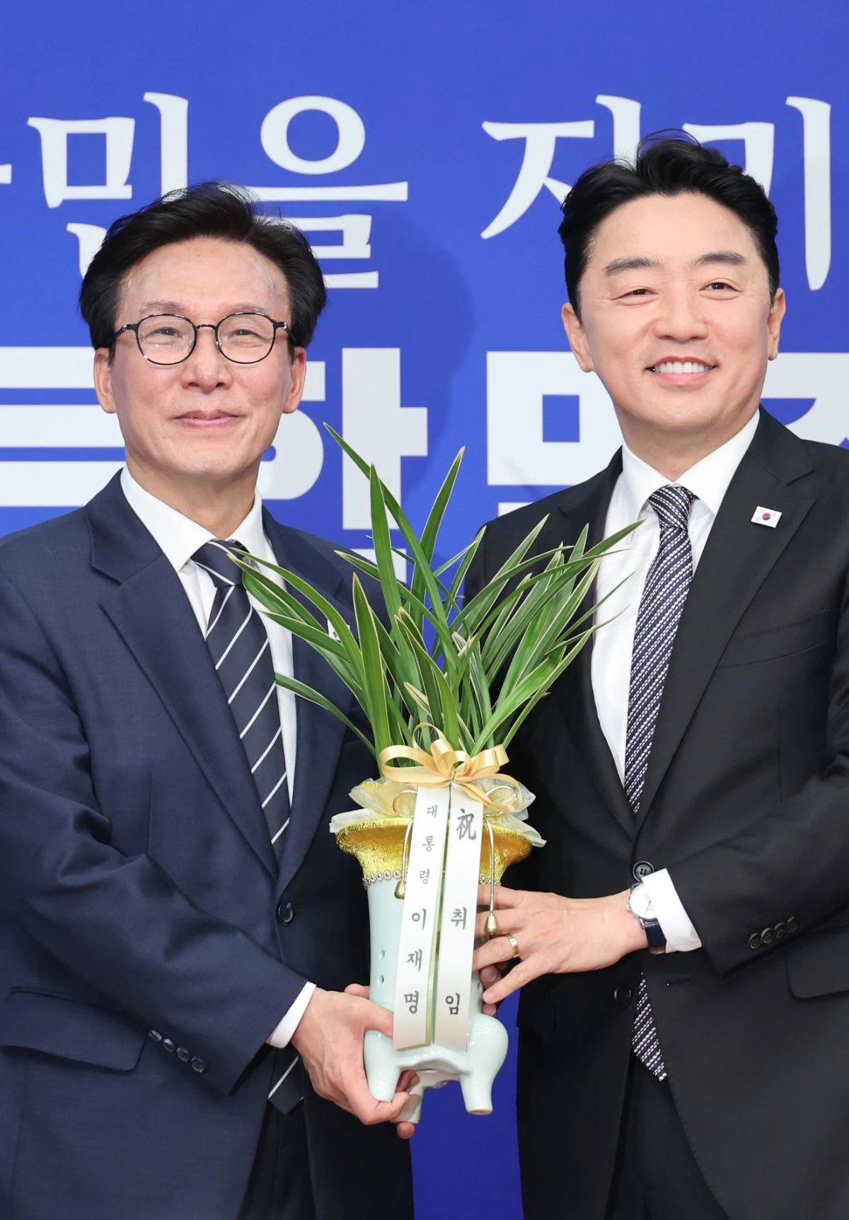 김민석 더불어민주당 신임 당대표에게 축하 난 전한 강훈식 대통령 비서실장. / 뉴스1