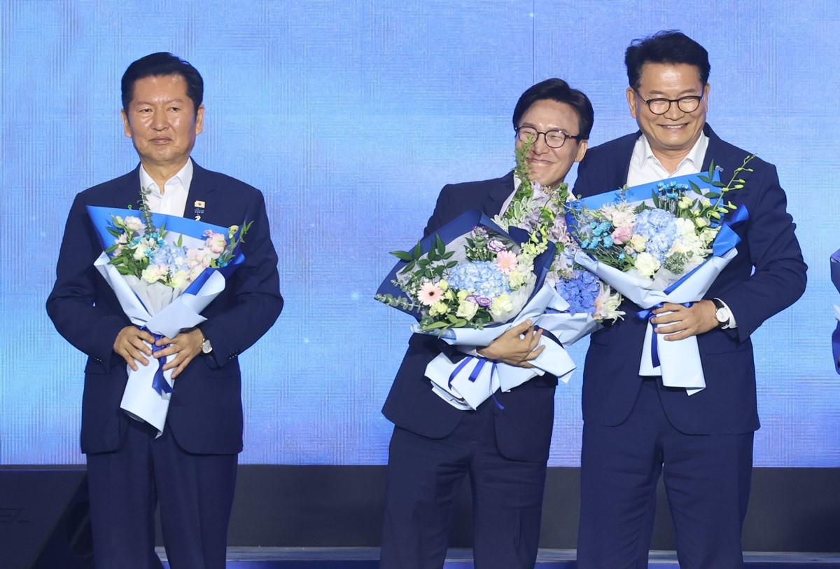 김민석 더불어민주당 신임 대표가 17일 대전 유성구 대전컨벤션센터(DCC) 제2전시장에서 열린 제3차 정기전국당원대회에서 정청래, 송영길 후보와 꽃다발을 받고 기념촬영을 하고 있는 모습 / 뉴스1