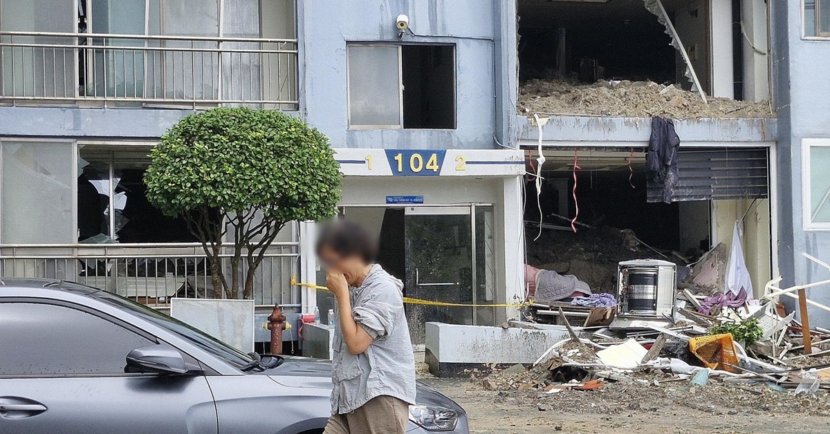 18일 극한 호우로 발생한 산사태 피해를 입은 경남 거제시 옥포동의 한 아파트에서 주민이 피해 현장을 본 뒤 눈물을 흘리고 있다. / 뉴스1
