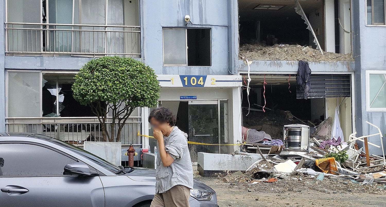 18일 극한 호우로 발생한 산사태 피해를 입은 경남 거제시 옥포동의 한 아파트에서 주민이 피해 현장을 본 뒤 눈물을 흘리고 있다. / 뉴스1