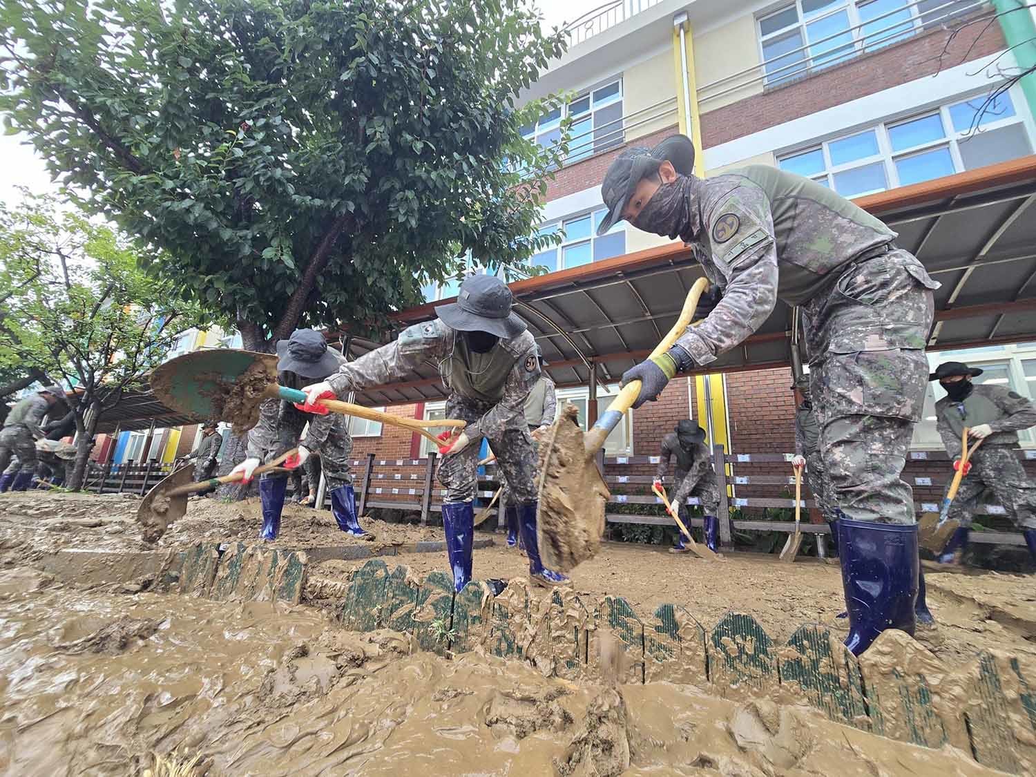 육군 제39보병사단 장병들이 18일 경남 거제시 장평초등학교에서 집중호우로 쌓인 토사와 잔해물을 제거하며 학교시설 복구에 힘을 보태고 있다. / 육군 제공