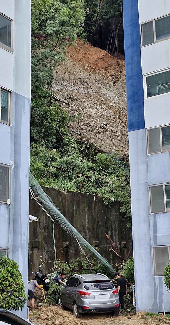 18일 극한 호우로 발생한 산사태 피해를 입은 경남 거제시 옥포동의 한 아파트에서 주민들이 토사에 묻힌 차량을 빼내기 위해 흙을 파고 있다. / 뉴스1
