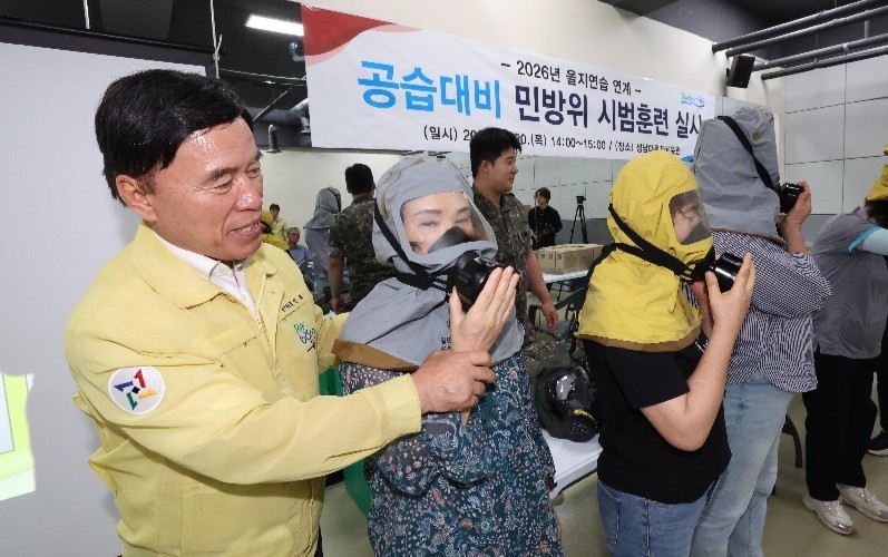 황인호 대전 동구청장이 20일 성남다목적체육관에서 열린 공습대비 민방위 시범훈련에서 주민의 방독면 착용을 돕고 있다./사진=대전 동구