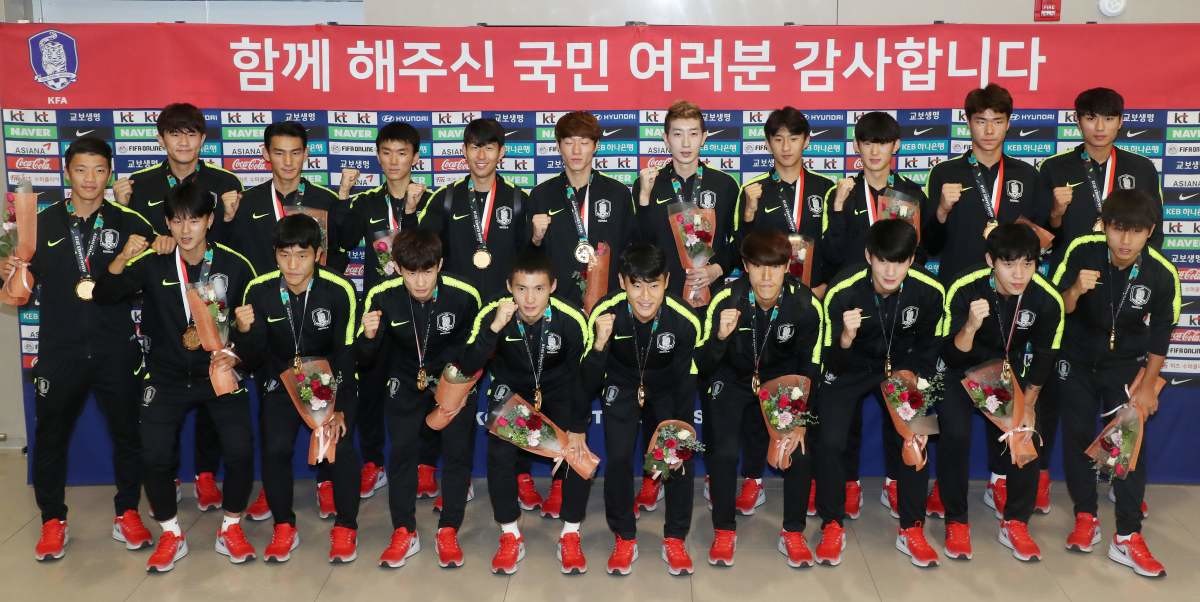 2018 자카르타-팔렘방 아시안게임 남자 축구 대표팀 선수들이 인천국제공항 제2여객터미널을 통해 입국, 축하 꽃다발을 든 채 포즈를 취하고 있다. / 뉴스1
