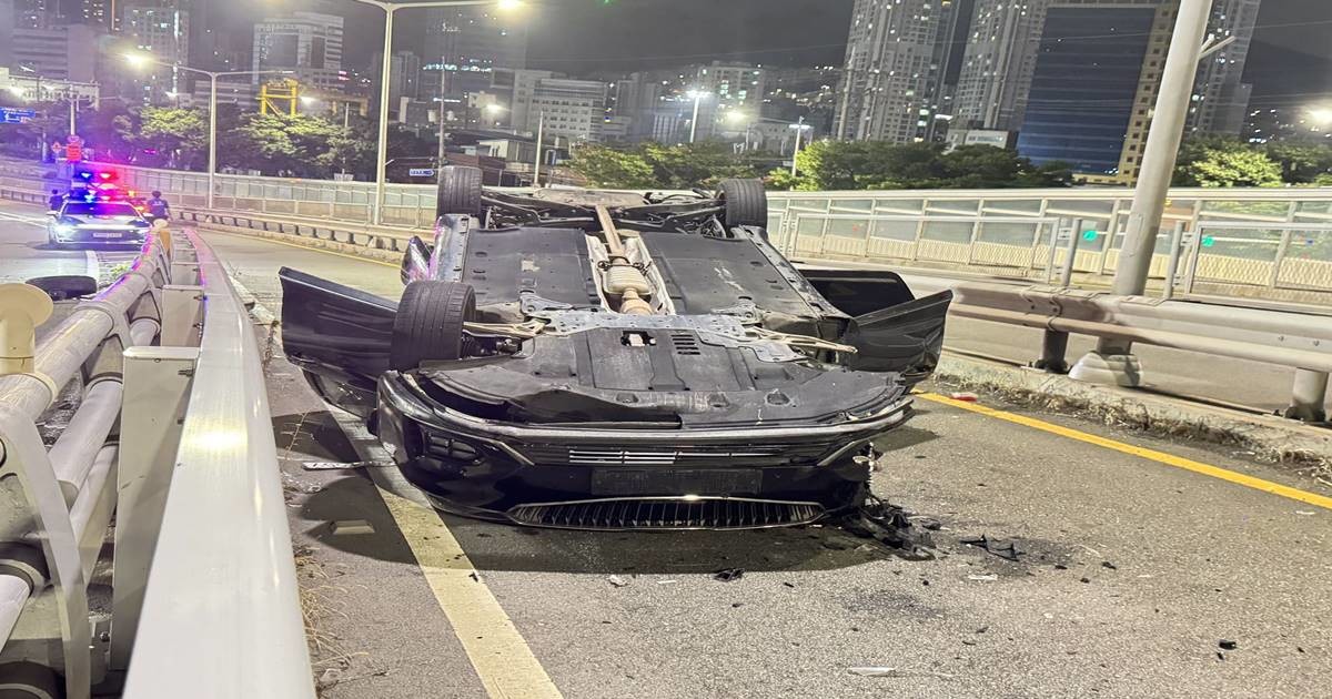 지난 21일 오후 11시께 부산 동구 좌천동 충장로고가교 진입로에서 승용차가 충격흡수시설을 들이받은 뒤 전복돼 있다. 사고 충격으로 차량 일부가 파손되고 잔해가 도로에 흩어져 있으며, 출동한 경찰이 현장을 통제하고 있다. 사진=최학봉 기자