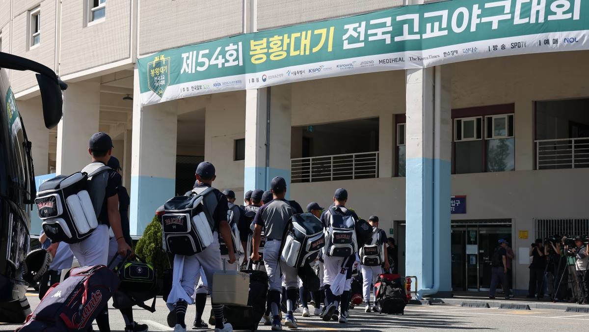 배재고등학교 야구부 선수들이 12일 목동야구장에서 열린 54회 봉황대기 전국고교야구대회 인천고와의 1회전 경기를 위해 경기장으로 향하고 있다.  / 연합뉴스