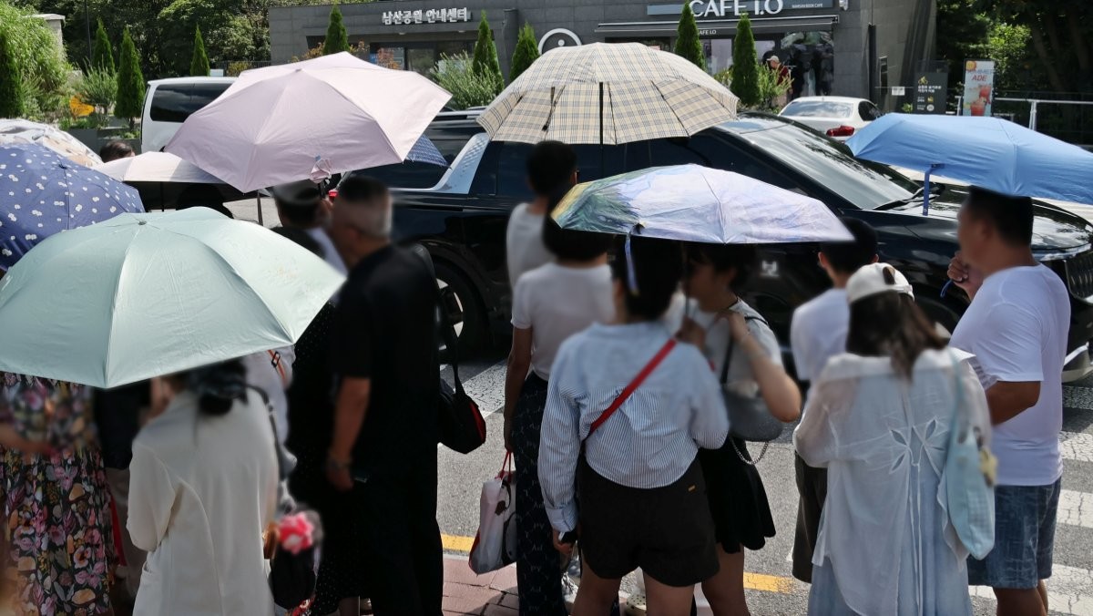 서울을 찾은 외국인 관광객들이 양산을 쓰고 있다. 기사 이해를 돕기 위한 자료사진. / 연합뉴스