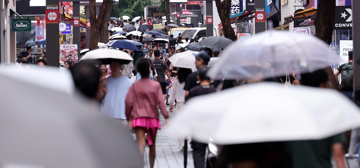 서울 중구 명동거리에서 외국인 관광객들이 우산을 쓴채 이동하고 있다. / 뉴스1