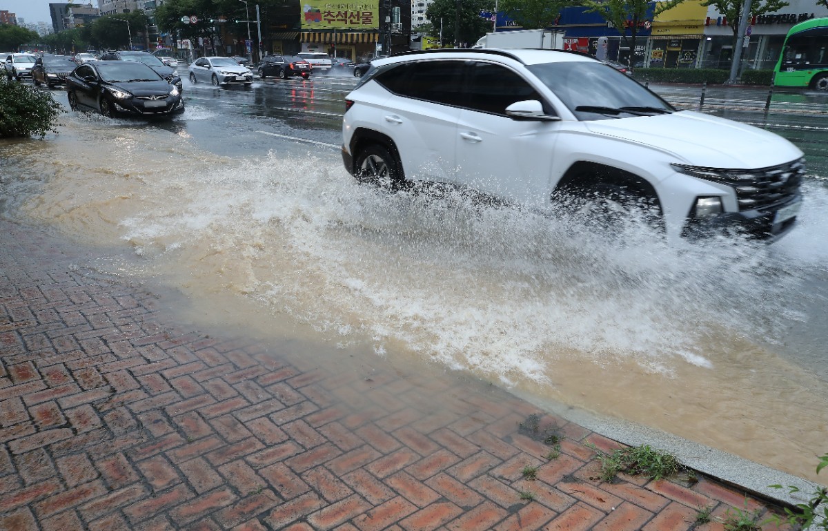 지난 30일 오후 대구 수성구 달구벌대로에 천둥번개를 동반한 폭우가 쏟아져 도로 옆 물웅덩이를 지나는 차량이 물보라를 일으키고 있는 모습 / 뉴스1