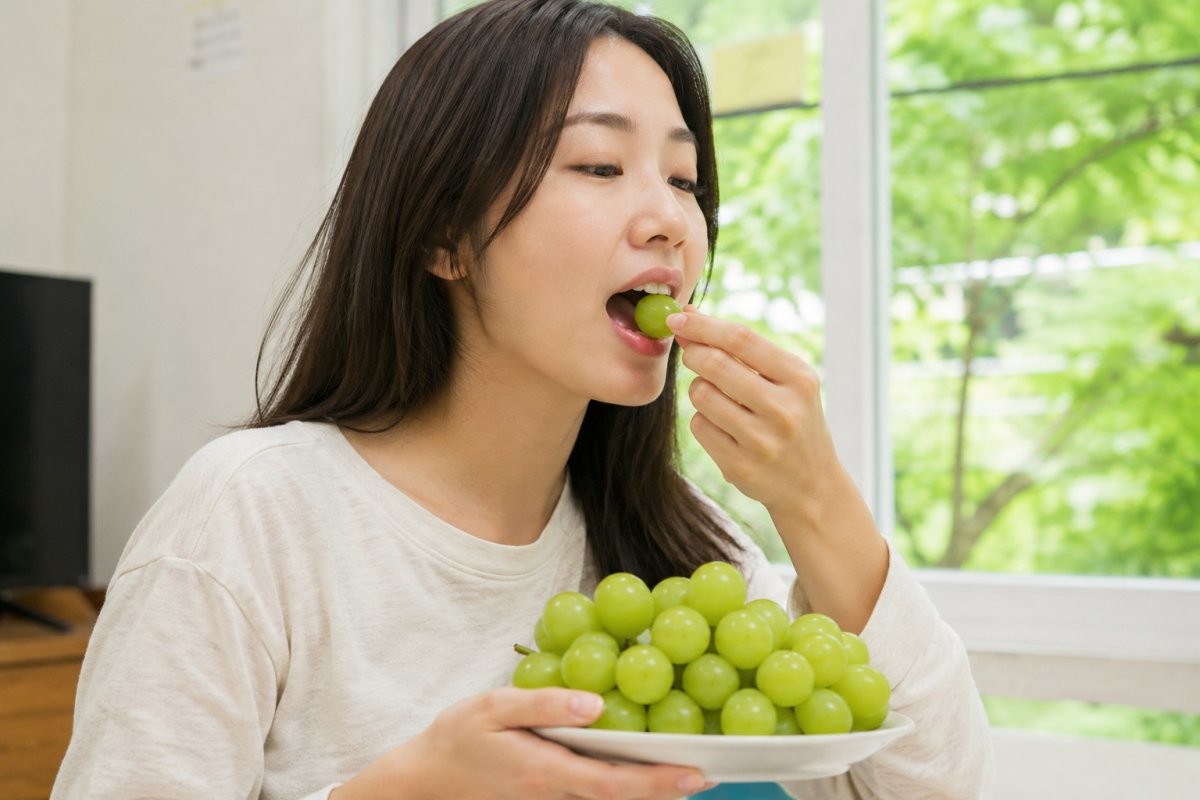 샤인머스캣 먹는 사람. 기사 내용을 바탕으로 AI툴로 생성한 자료사진.