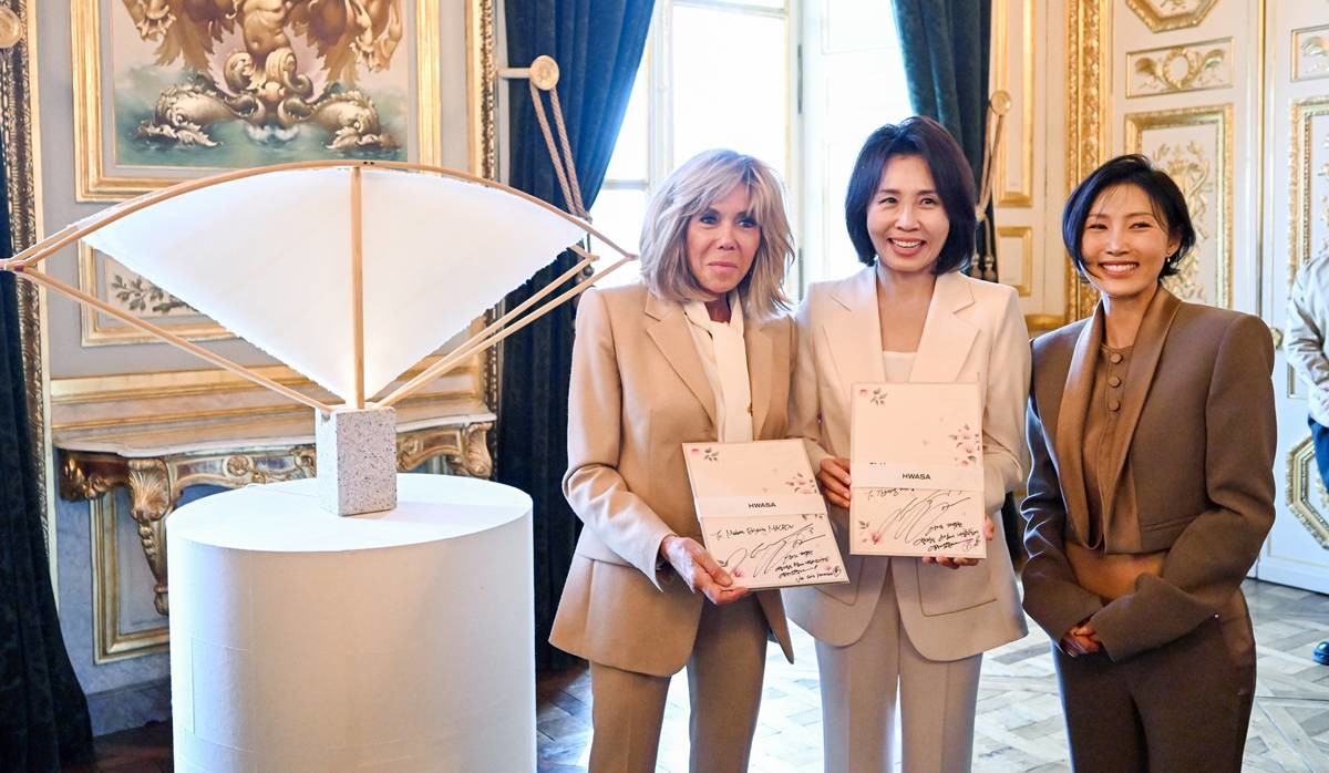 김혜경 여사와 프랑스 대통령 부인 브리지트 마크롱 여사가 8일(현지시간) 파리 오텔 드 라 마린에서 열린 한지마니아 특별전에서 가수 화사와 한지 케이스 앨범을 들고 기념촬영을 하고 있다 / 뉴스1
