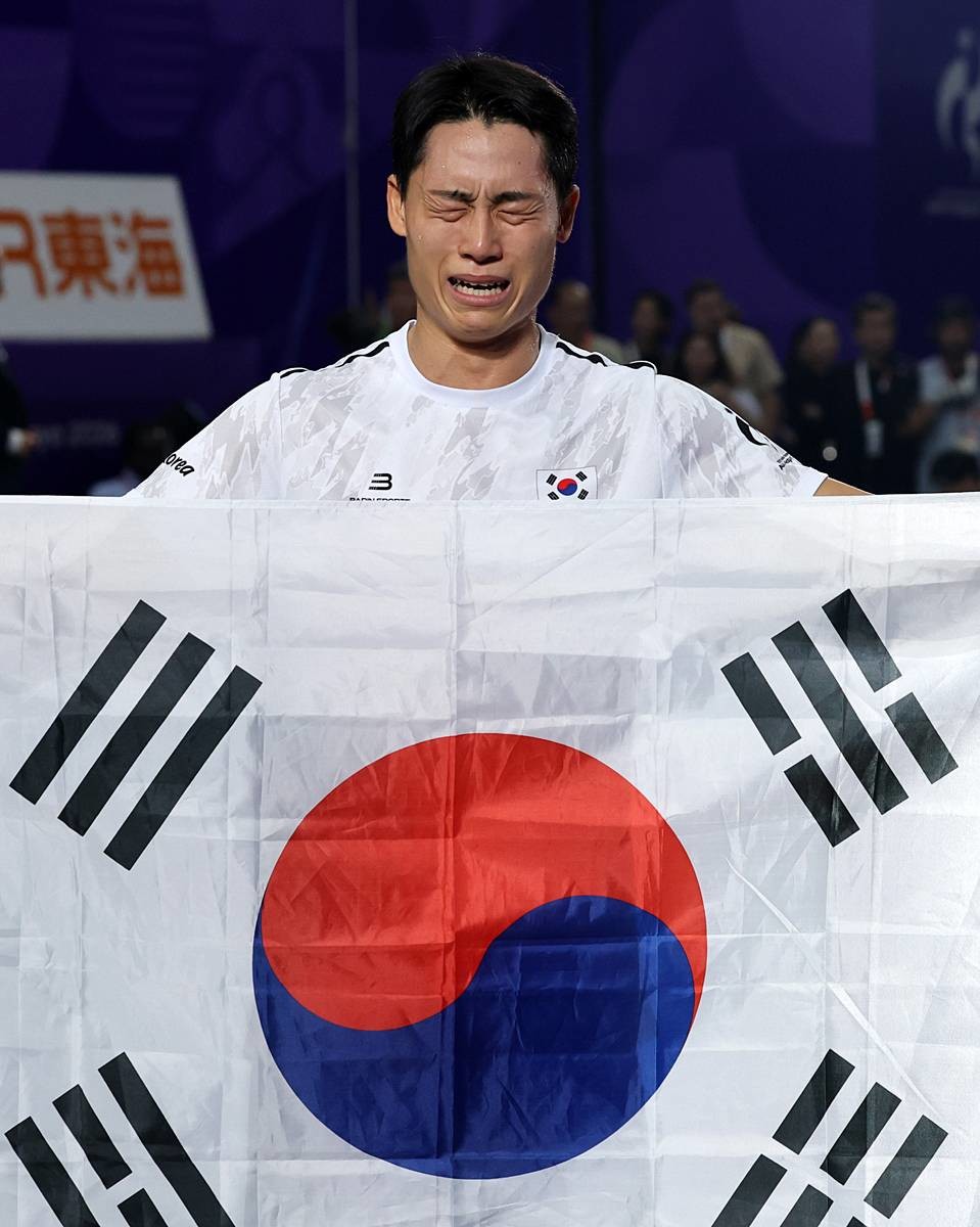한국 테크볼 사상 첫 국제종합스포츠대회 메달리스트가 된 이준석이 20일 일본 나고야 히가시 스포츠센터에서 열린 2026 아이치·나고야 아시안게임 테크볼 남자 단식 결승전에서 금메달을 따낸 후 태극기를 들고 눈물을 흘리고 있다 / 뉴스1