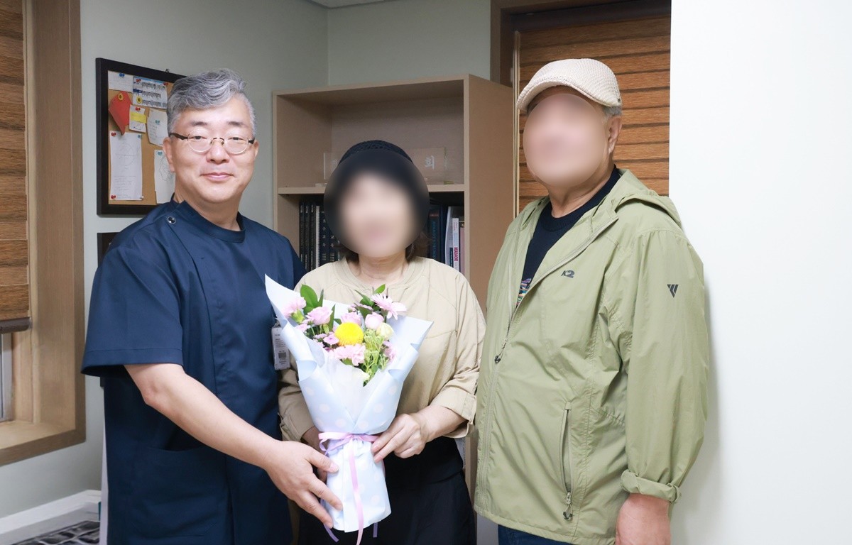 세명기독병원 뇌병원 조상희 원장이 레켐비 18개월 치료 과정을 마친 권 모 씨·권씨의 남편과 함께 기념 촬영을 하고 있다. / 이하 병원 제공