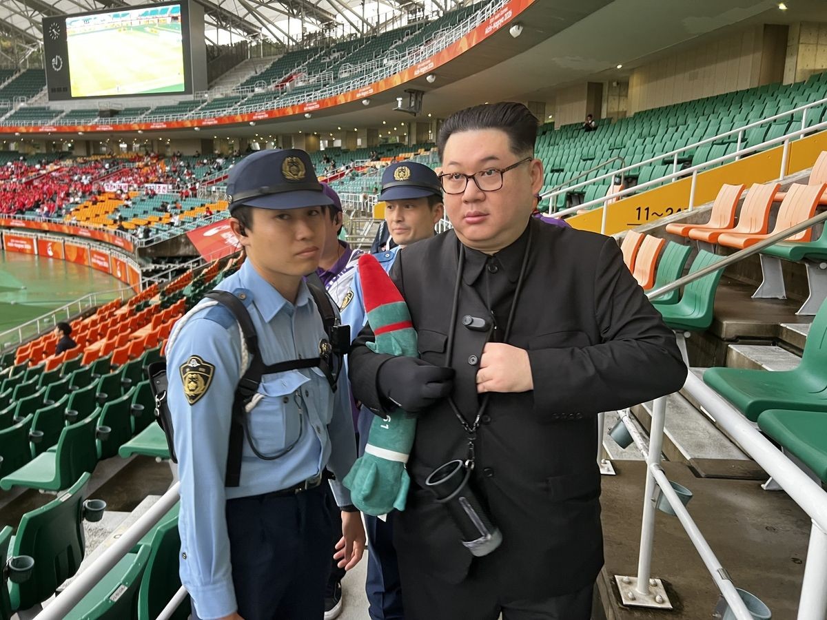 21일 일본 시즈오카현 후쿠로이의 시즈오카 스타디움 에코파에서 열린 2026 아이치·나고야 아시안게임 여자 축구 조별리그 대한민국과 북한의 경기 관중석에서 김정은 북한 국무위원장 분장을 한 남성이 북측 응원단으로 접근하다 경찰 측에 제지당하고 있다. / 연합뉴스