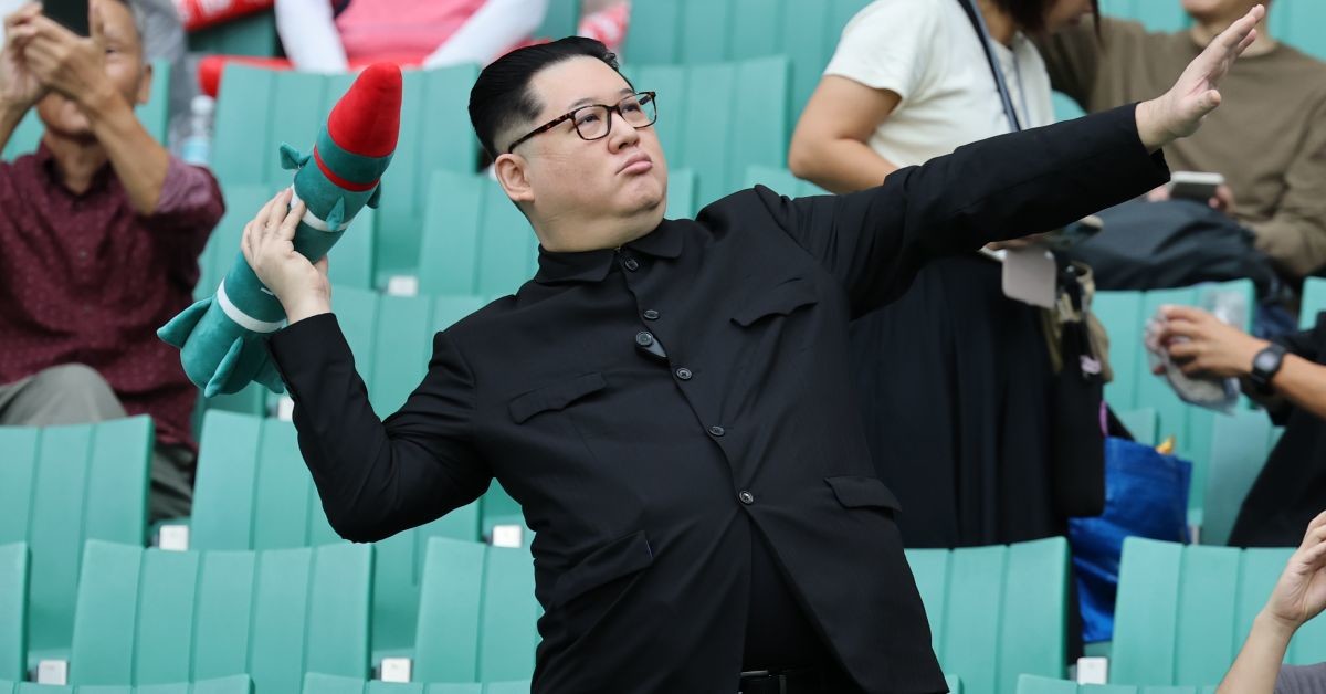 21일 일본 시즈오카 스타디움 에코파에서 열린 2026 아이치·나고야 아시안게임 조별예선 F조 대한민국과 북한의 경기를 찾은 중국계 정치활동가 '하워드X'가 북한 김정은 국무위원장이 로켓을 든 모습을 표현하고 있다. / 뉴스1