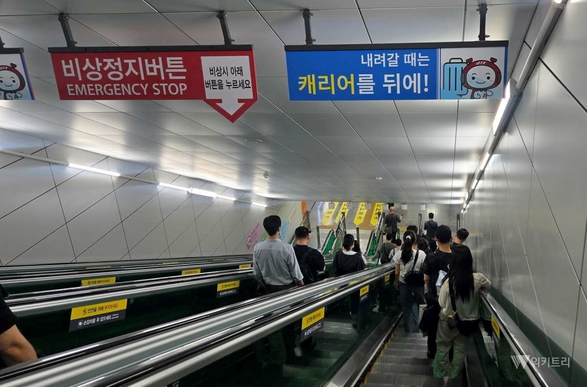 에스컬레이터를 타고 내려가고 있는 승객들 / 위키트리