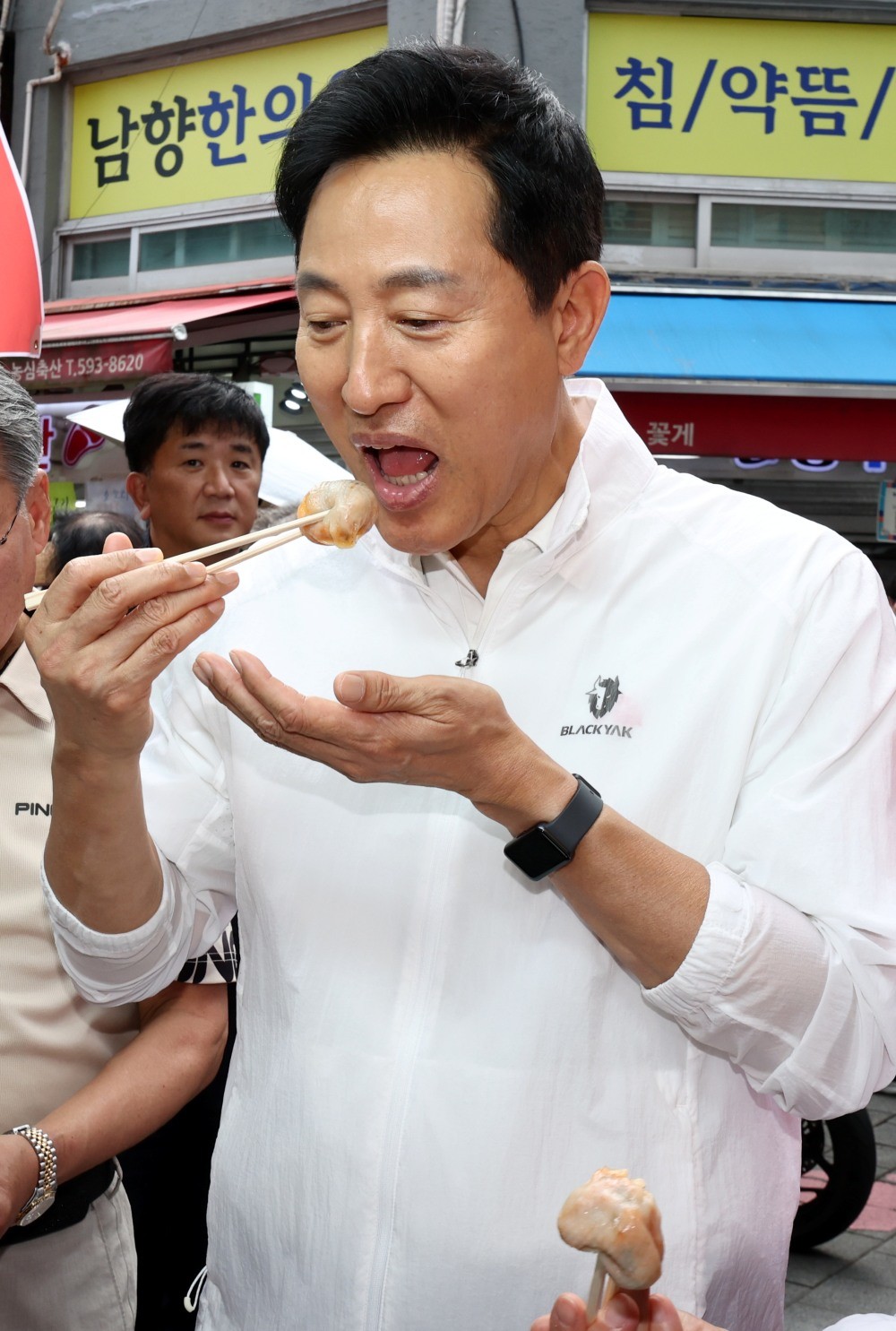 오세훈 서울시장이 추석을 앞둔 23일 서울 동작구 남성사계시장을 찾아 한 만두를 먹고 있다. / 뉴스1
