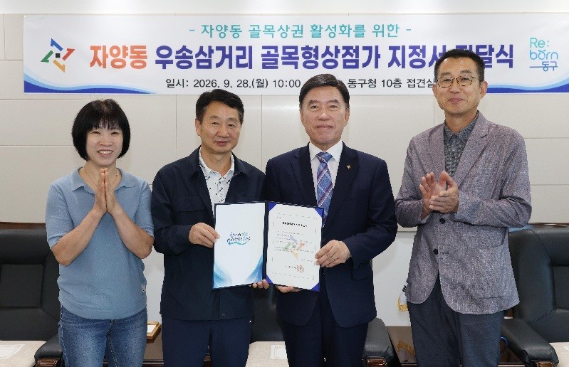 황인호 동구청장이 28일 ‘자양동 우송삼거리 골목형상점가’ 지정서를 전달하고 상인회 관계자들과 기념촬영을 하고 있다./사진=대전 동구