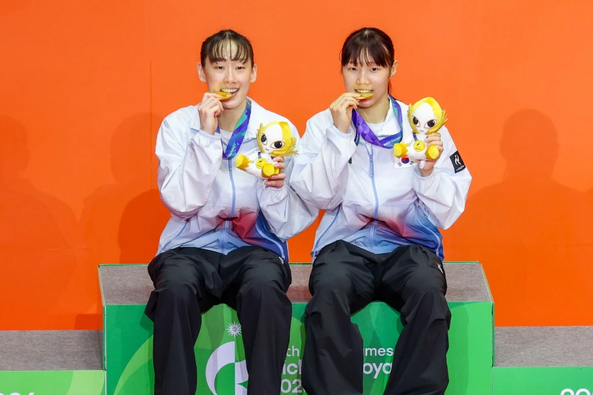 대한민국 이소희(왼쪽), 백하나가 29일 일본 이치노미야 시립체육관에서 열린 2026 아이치·나고야 아시안게임 배드민턴 여자 복식 시상식에서 금메달을 꺠물고 있다. / 뉴스1