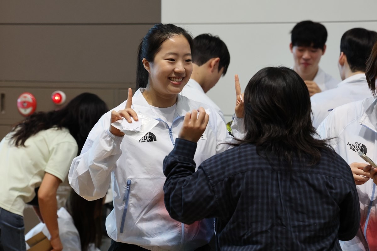대한민국 탁구 국가대표팀의 신유빈이 2026 아이치·나고야 아시안게임 개막을 이틀 앞두고 있던 지난 17일 오전 인천국제공항에서 일본으로 출국하기 앞서 팬과 웃으며 대화를 나누고 있다. / 뉴스1