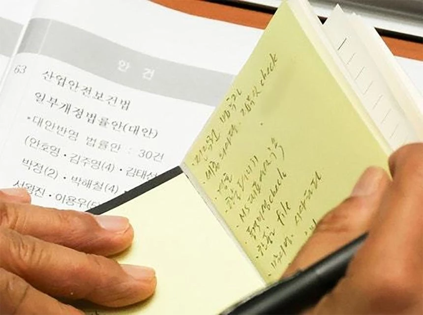김민석 더불어민주당 대표가 1일 오후 서울 여의도 국회에서 제439회(정기회) 제10차 본회의 도중 수첩에 적힌 포스트잇 메모를 확인하고 있다. / 한동훈 의원 페이스북 캡처