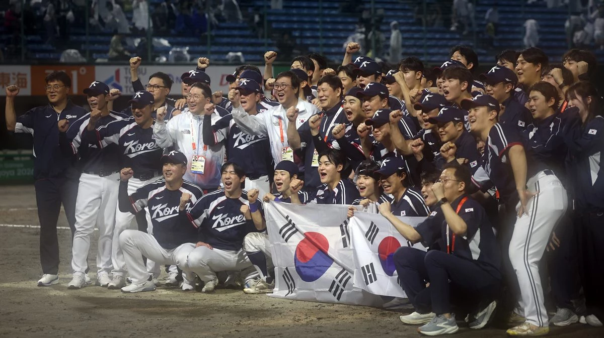 27일 일본 아이치현 도요하시 시민구장에서 열린 2026 아이치·나고야 아시안게임 야구 결승에서 금메달을 차지한 대한민국 대표선수들이 최휘영 문화체육관광부 장관, 허구연 한국야구위원회 (KBO) 총재 등과 기념 촬영을 하고 있다. / 연합뉴스