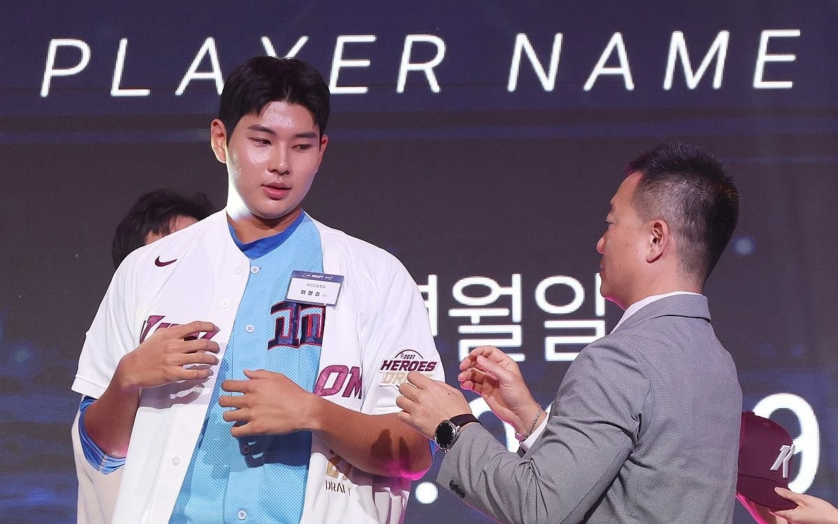 지난 9월 21일 서울 롯데호텔 월드에서 열린 '2027 KBO 신인 드래프트'에서 전체 1순위로 키움 히어로즈의 지명을 받은 부산고 하현승이 유니폼을 받아 입고 있다. / 연합뉴스
