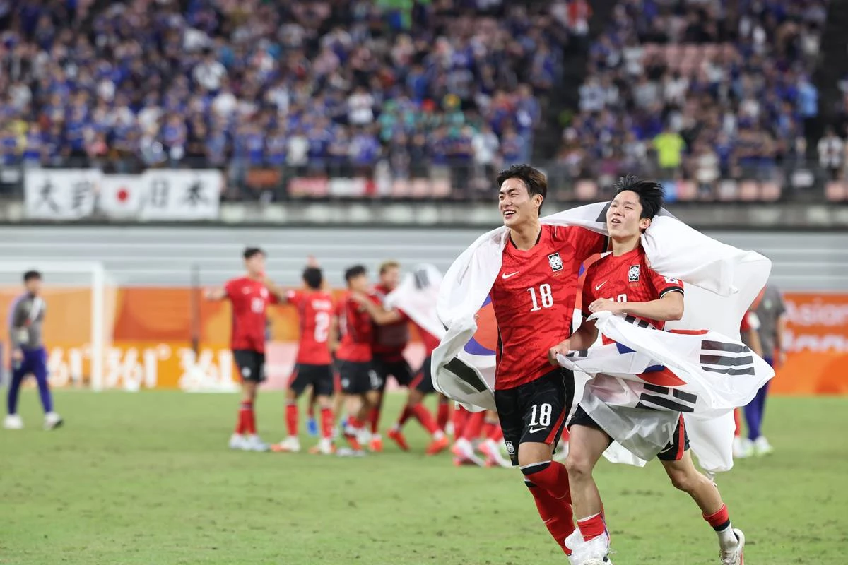 지난 3일 일본 아이치현 도요타 스타디움에서 열린 2026 아이치·나고야 아시안게임 남자 축구 결승전 대한민국과 일본의 경기, 1대 0으로 승리하며 금메달을 획득한 대한민국의 김명준,양민혁이 태극기를 두르고 기쁨을 나누고 있다 / 뉴스1