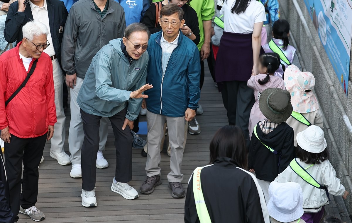 이명박 전 대통령이 8일 서울 청계천에서 '청계천을 사랑하는 모임'(청사모) 구성원들과 청계천을 걸고 있다. 이명박 전 대통령은 현 정부(이재명 정부)의 국정 운영에 관해 묻자 말을 아끼면서도 '대통령이 이제 국민의 소리에 귀 기울이지 않겠나. 점점 더 나아질 것'이라며 '야당의 소리에 귀 기울일 게 아니라 국민의 소리를 듣는 게 중요하다'라고 강조했다. 이 전 대통령은 청사모 구성원 등과 이날 오전 10시 서울 중구 청계광장에서 출발해 성동구 신답철교까지 5.8㎞를 약 2시간 가까이 걸었다. / 연합뉴스