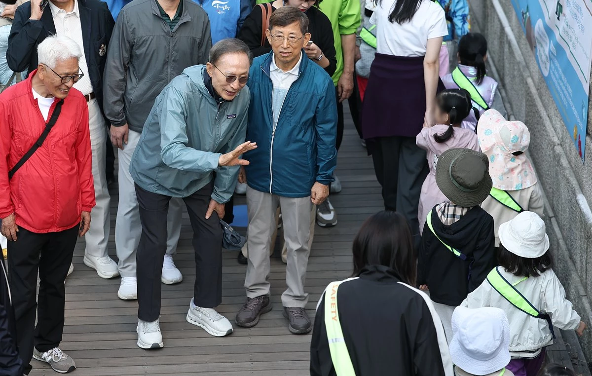 이명박 전 대통령이 8일 서울 청계천에서 '청계천을 사랑하는 모임'(청사모) 구성원들과 청계천을 걸고 있다. 이명박 전 대통령은 현 정부(이재명 정부)의 국정 운영에 관해 묻자 말을 아끼면서도 '대통령이 이제 국민의 소리에 귀 기울이지 않겠나. 점점 더 나아질 것'이라며 '야당의 소리에 귀 기울일 게 아니라 국민의 소리를 듣는 게 중요하다'라고 강조했다. 이 전 대통령은 청사모 구성원 등과 이날 오전 10시 서울 중구 청계광장에서 출발해 성동구 신답철교까지 5.8㎞를 약 2시간 가까이 걸었다. / 연합뉴스