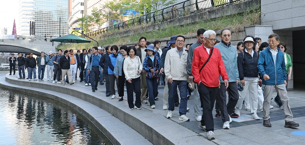 이명박 전 대통령이 8일 서울 청계천에서 '청계천을 사랑하는 모임'(청사모) 구성원들과 청계천을 걸고 있다. 이명박 전 대통령은 현 정부(이재명 정부)의 국정 운영에 관해 묻자 말을 아끼면서도 '대통령이 이제 국민의 소리에 귀 기울이지 않겠나. 점점 더 나아질 것'이라며 '야당의 소리에 귀 기울일 게 아니라 국민의 소리를 듣는 게 중요하다'라고 강조했다. 이 전 대통령은 청사모 구성원 등과 이날 오전 10시 서울 중구 청계광장에서 출발해 성동구 신답철교까지 5.8㎞를 약 2시간 가까이 걸었다. / 연합뉴스