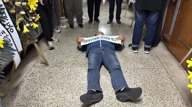 12일 대덕구의회 의장 선출이 또다시 무산된 가운데, 한 주민이 의회 앞 복도에 드러누워 ‘대덕구의회 정상화 촉구’ 문구가 적힌 손팻말을 들고 항의하고 있다./사진=김지연 기자