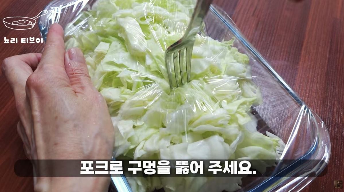 양배추에 전자레인지 랩을 씌운 뒤 포크로 구멍을 뚫는 모습. / 유튜브 '뇨리 티브이'