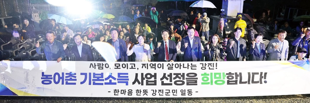 남미륵사 산사음악회에 참석한 강진원 강진군수를 비롯한 주요 인사들이 농어촌 기본소득 시범사업 선정을 희망하는 내용을 담은 현수막을 들고 있다. / 강진군