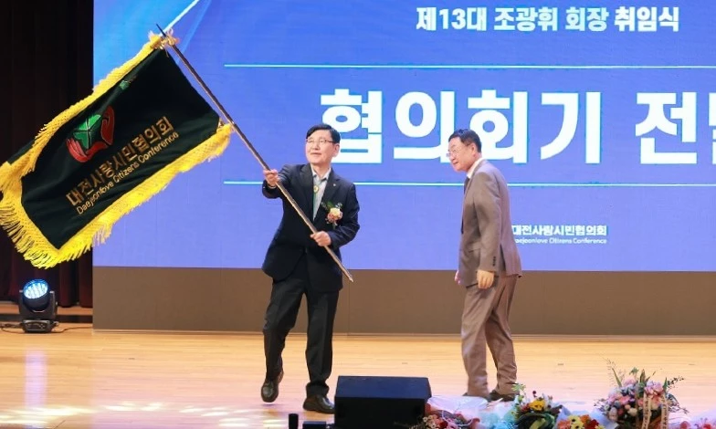 조광휘 제13대 대전사랑시민협의회장이 19일 대전시청 대강당에서 열린 취임식에서 남재동 제12대 회장으로부터 전달받은 협의회기를 흔들고 있다./사진=대전시