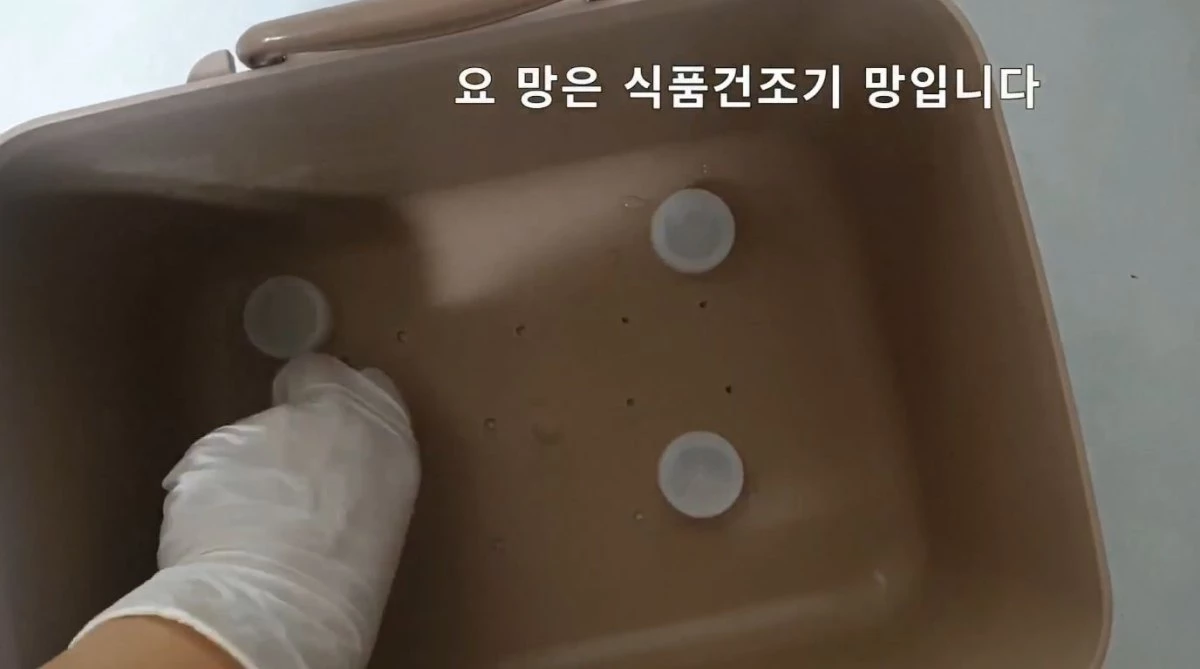 김치통 아래에 페트병 뚜껑을 두는 모습. / 유튜브 '주부나라'