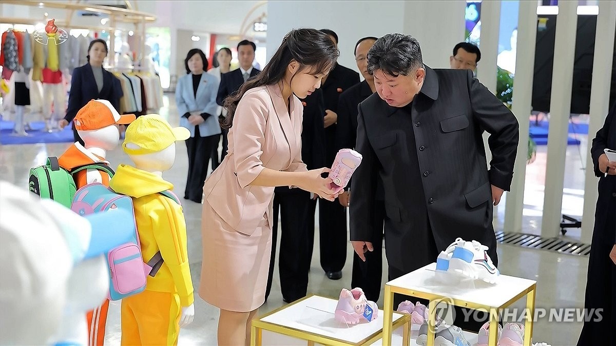 북한 김정은이 지난 19일 '전국피복, 신발전시회-2026'을 찾아 딸 김주애가 들어 보이는 분홍색 아동용 운동화를 살펴보고 있다. / 조선중앙TV 화면-연합뉴스