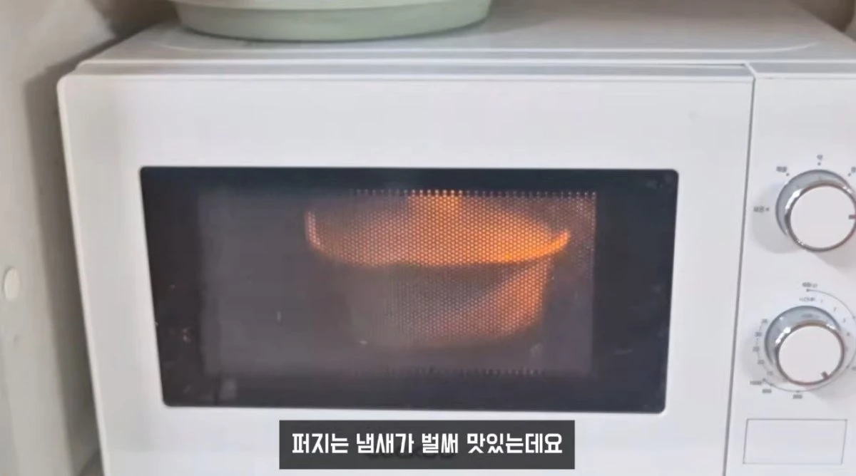 재료와 양념이 들어있는 전자레인지용 용기를 전자레인지에 넣고 조리하는 모습. / 유튜브 '야미양yummy | 간단한끼'