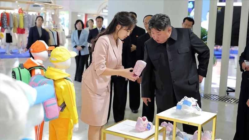 김정은 국무위원장이 지난 19일 '전국피복, 신발전시회-2026'을 찾아 딸 주애가 들어 보이는 분홍색 아동용 운동화를 살펴보고 있는 모습 / 조선중앙TV 화면 캡처