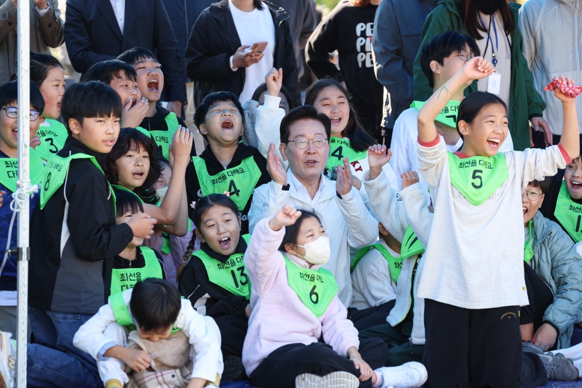 이재명 대통령이 22일 전북 익산 왕궁초등학교에서 열린 가을 행복학교 체육한마당에서 어린이들과 응원을 하고 있다. / 뉴스1