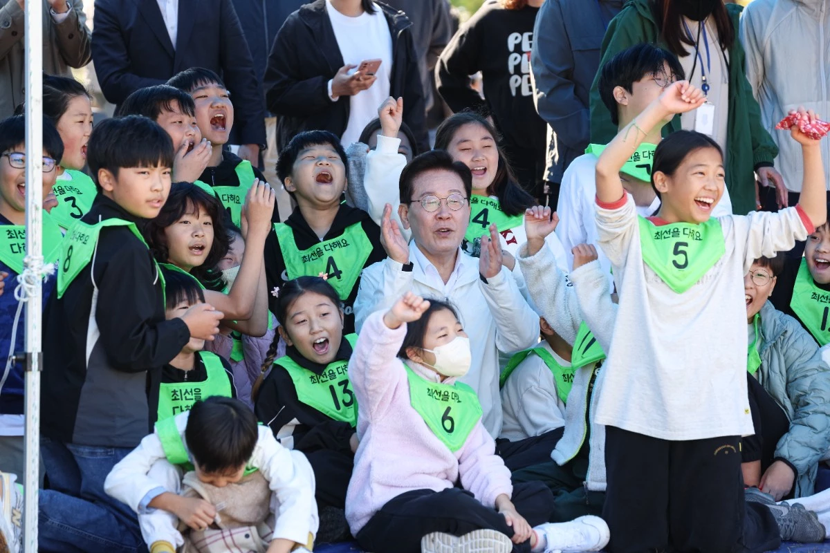 이재명 대통령이 22일 전북 익산 왕궁초등학교에서 열린 가을 행복학교 체육한마당에서 어린이들과 응원을 하고 있다. / 뉴스1