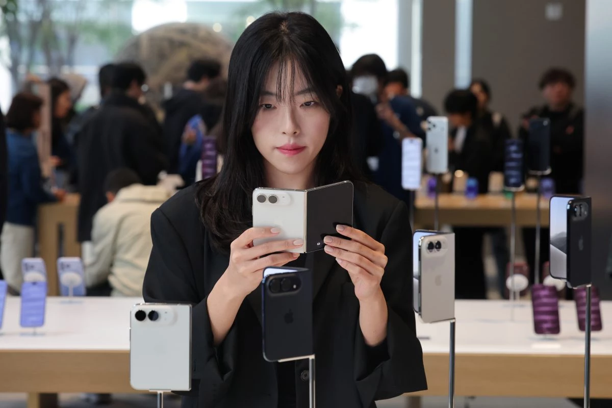 애플의 폴더블 스마트폰 아이폰 듀오 출시일인 23일 서울 중구 애플 명동점에서 관계자가 아이폰 듀오 제품을 살펴보고 있다. / 연합뉴스
