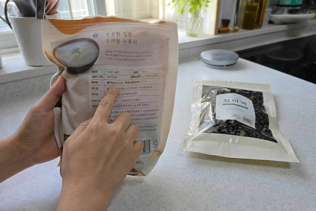 조리대 위 포장지 뒷면의 식품 정보를 손가락으로 짚는 모습 — AI 자료 이미지