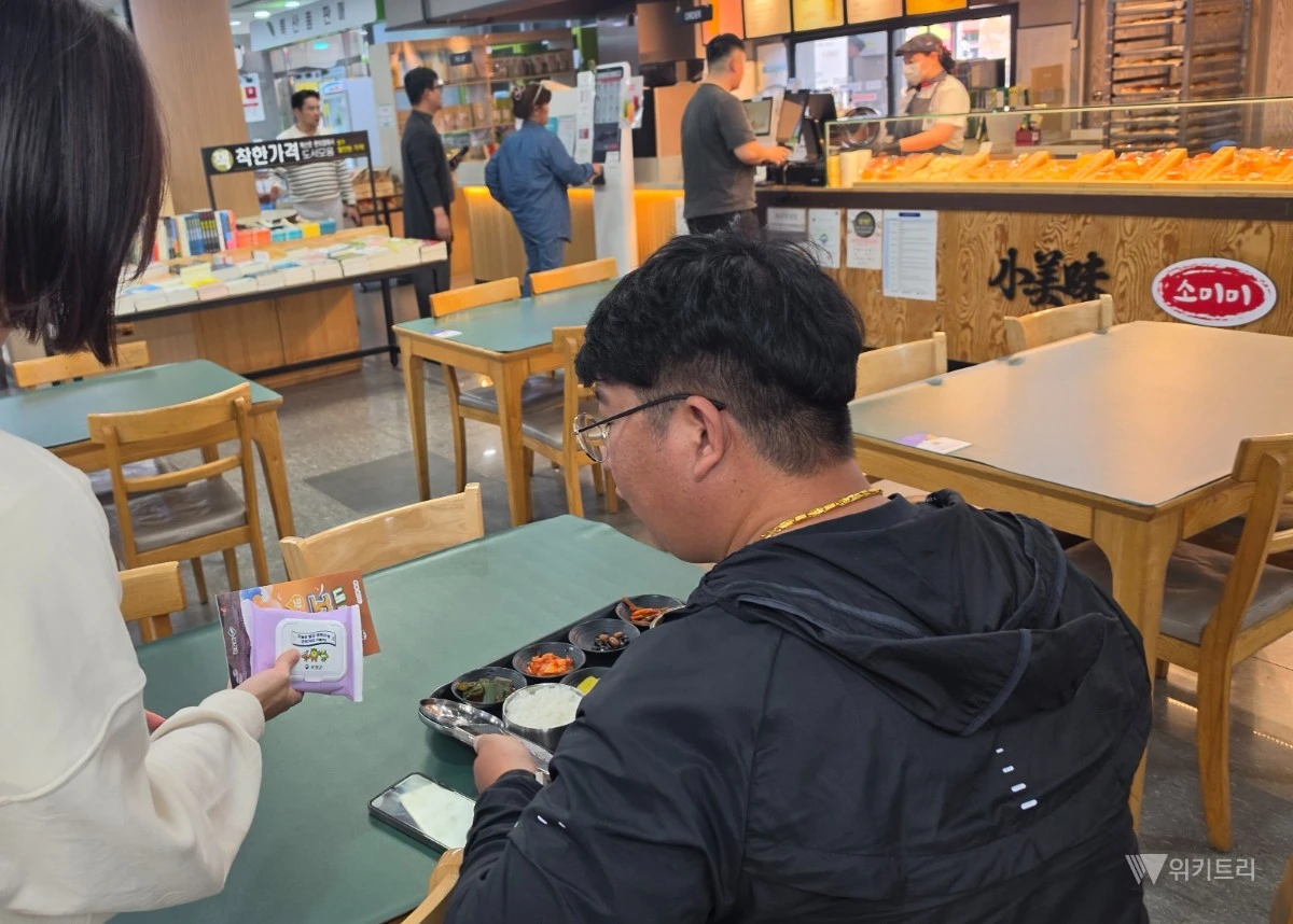 꼬막거리 내 맛집 지도(리플릿)와 홍보용 물티슈를 배부하고 있다.