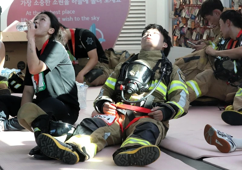 힘겨운 100층 도전 후 휴식을 취하는 소방관 / 뉴스1