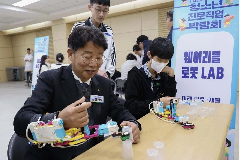 김찬술 대덕구청장(사진 왼쪽)이 28일 한남대학교 56주년기념관에서 ‘2026년 대덕구 청소년 진로직업박람회’에서 착용 가능한 로봇을 착용하고 의료·재활 기술을 체험하고 있다./사진=대덕구