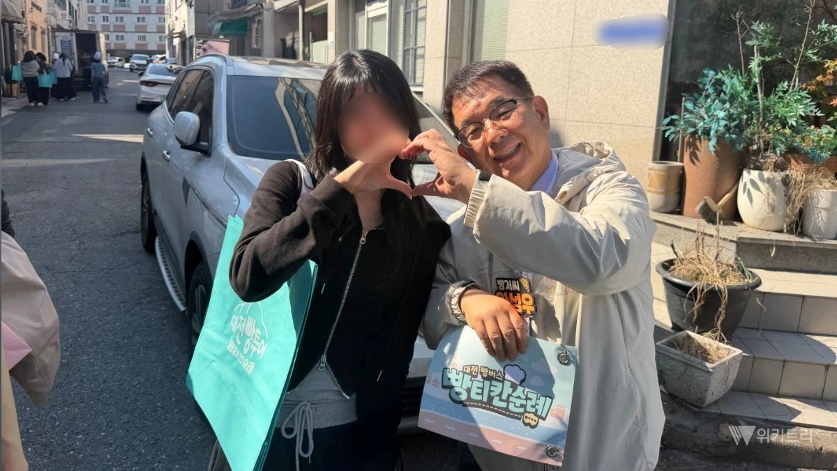 관광객들과 다정하게 사진을 찍는 '빵아저씨' 안성우 씨. / 위키트리