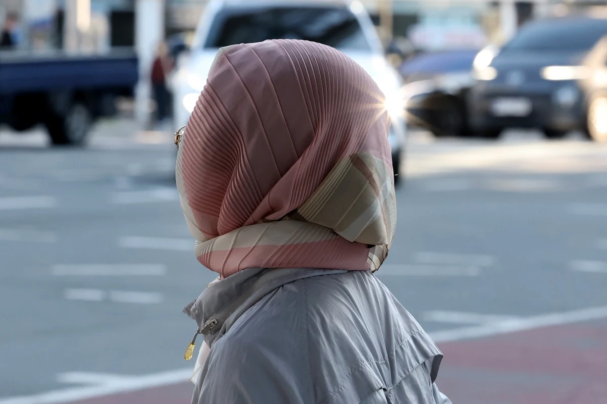 한 시민이 쌀쌀한 날씨에 스카프로 얼굴을 감싼 채 보행자 신호를 기다리고 있다. / 뉴스1